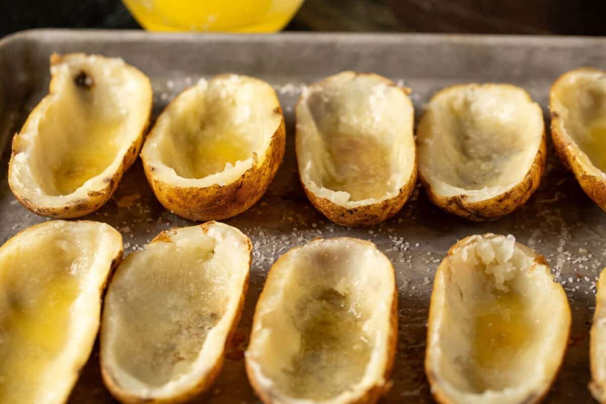 Hollowed potato skins on baking sheet.