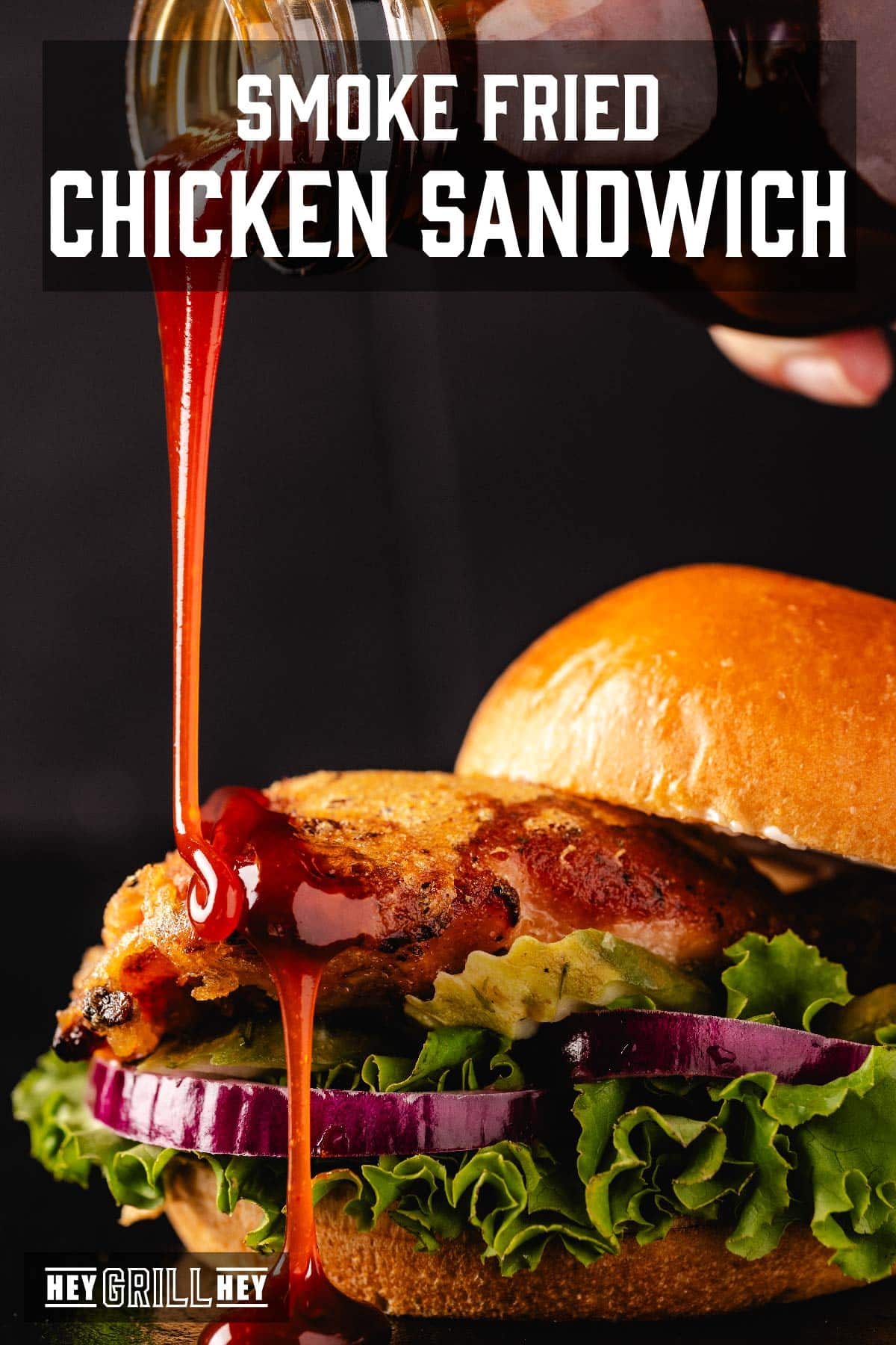 A hot chicken sandwich being drizzled with BBQ sauce from above. Text reads "Smoke Fried Chicken Sandwich."