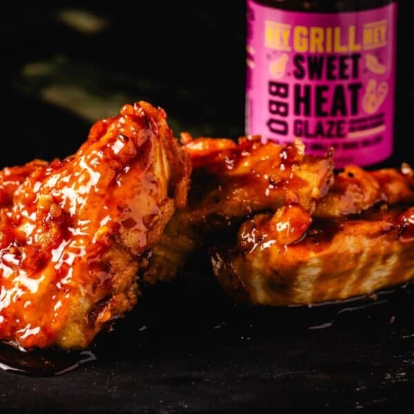 Sauced chicken next to bottle of Sweet Heat BBQ Glaze.