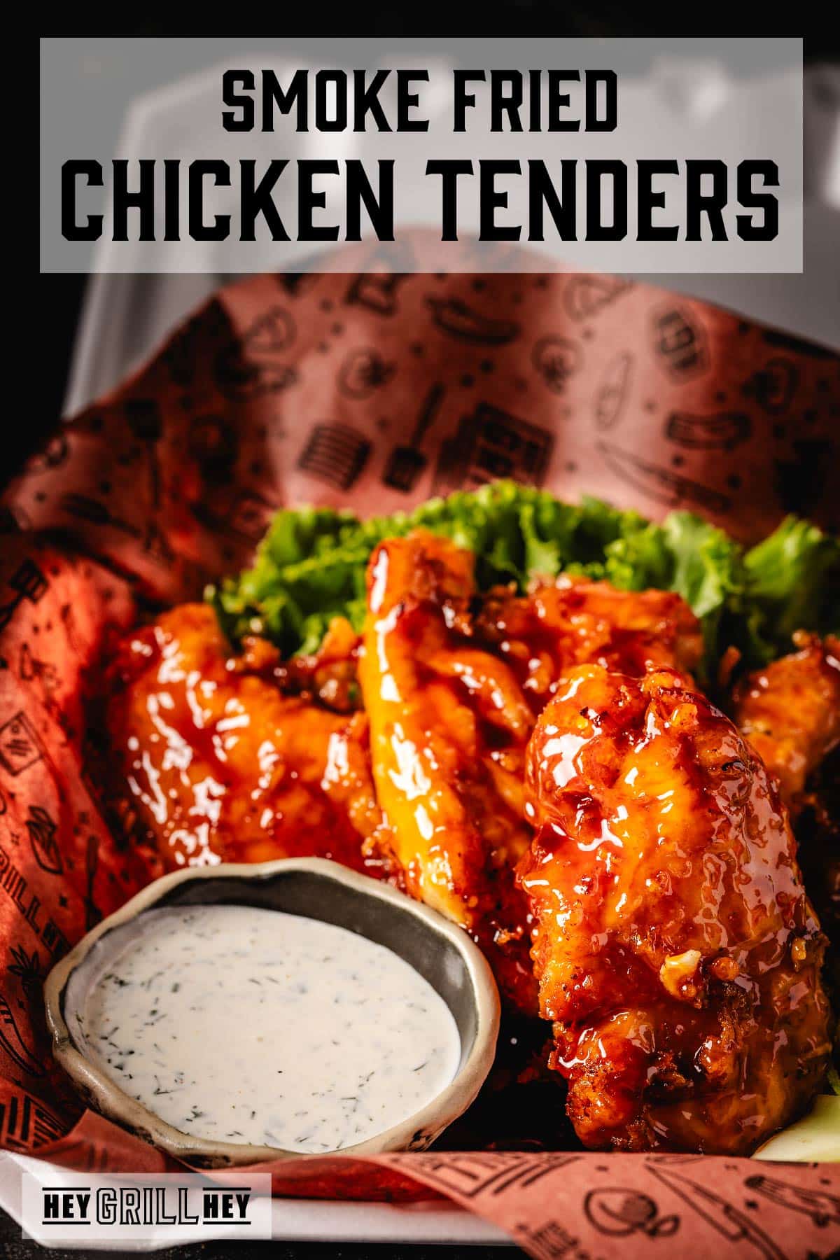 Glazed chicken tenders in basket with bowl of ranch. Text reads "Smoke Fried Chicken Tenders."