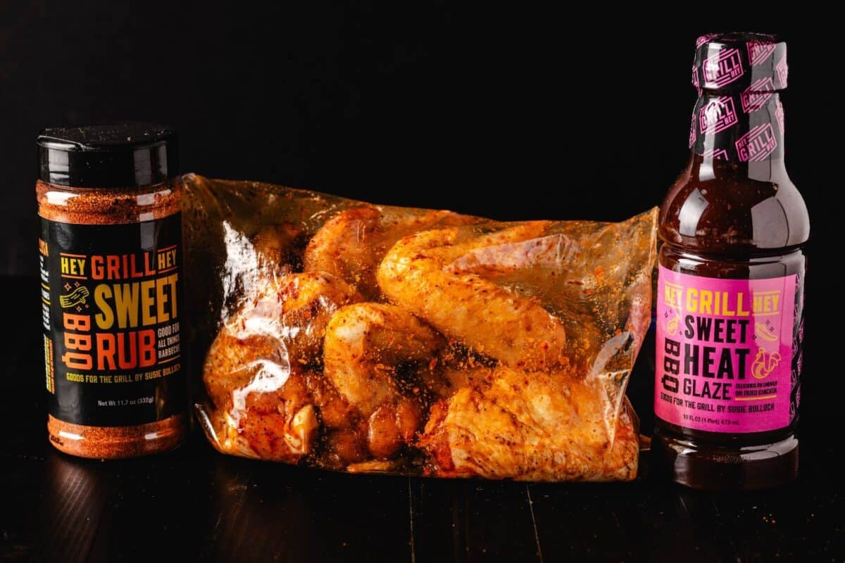 Wings in plastic bag next to bottles of rub and glaze.