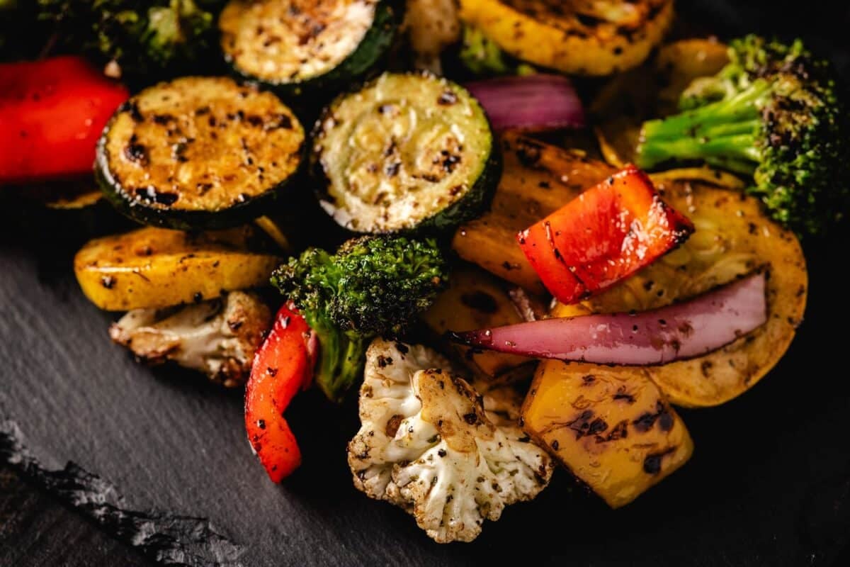 Grilled vegetables on a black serving platter.