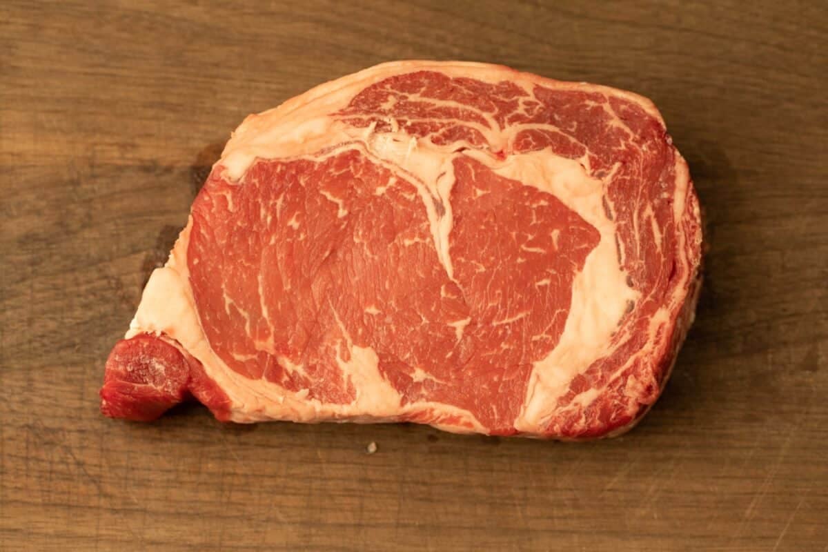 A choice-cut steak on a wooden cutting board.