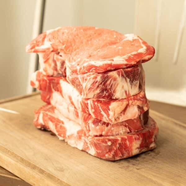 A stack or raw steaks representing the various grades of beef.