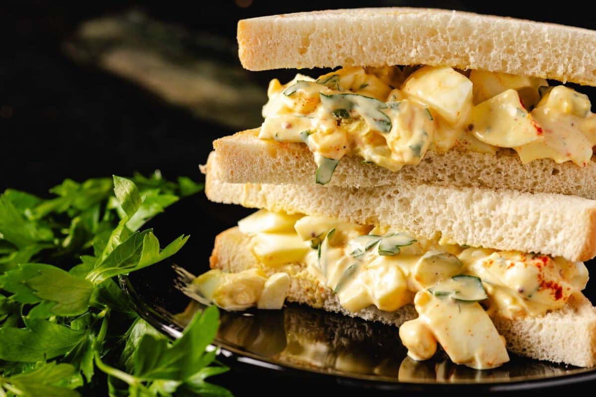 An egg salad sandwich with fresh garnish.