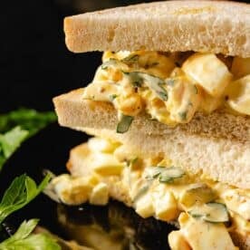 An egg salad sandwich with fresh garnish.