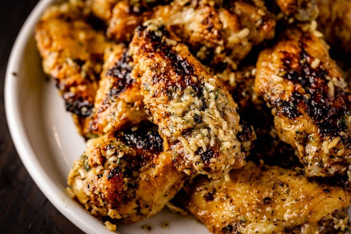 Garlic parmesan chicken wings on a white plate.