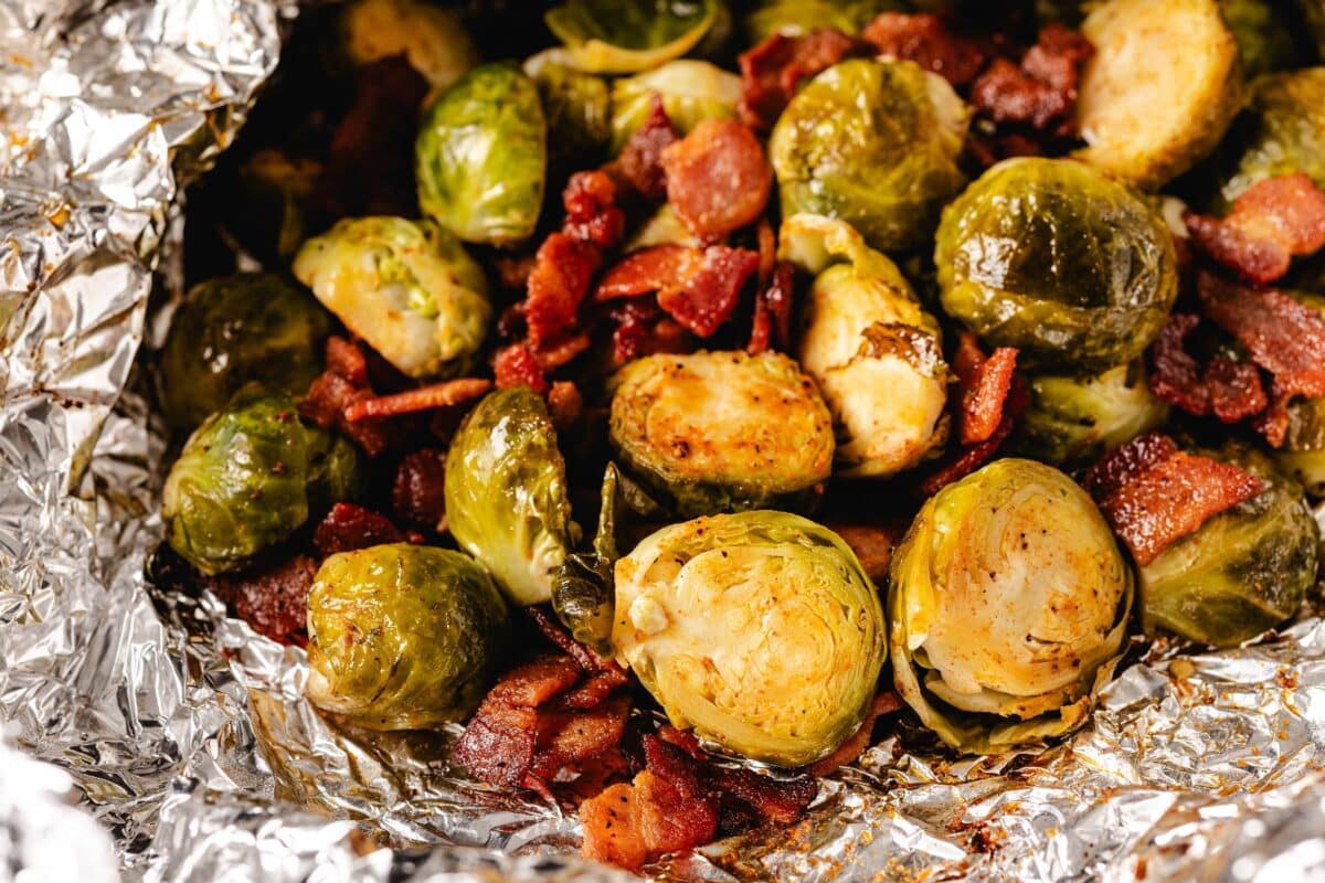 A foil packet opened up, revealing grilled bacon and veggies.