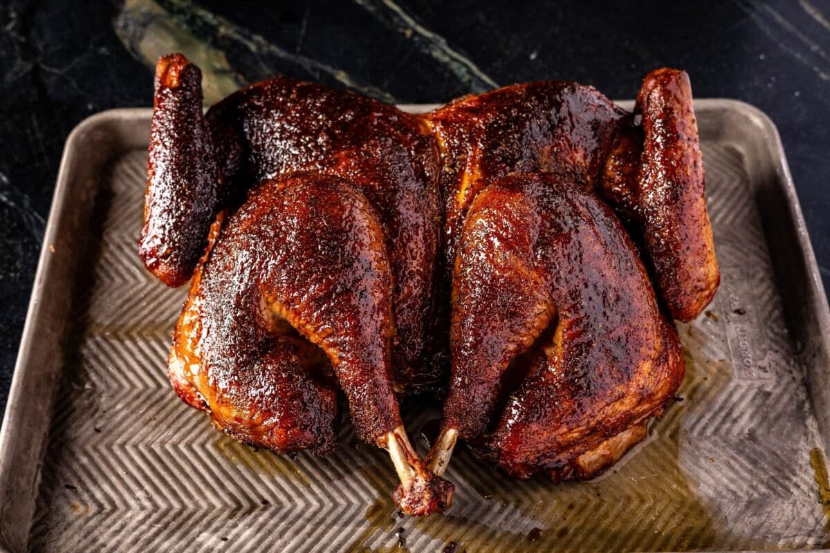 Smoked spatchcock turkey on a baking sheet.