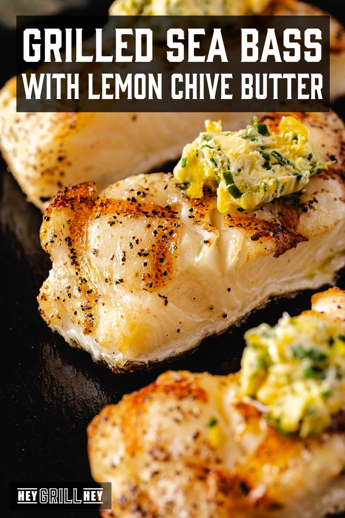 Grilled fish fillets on a serving platter. The text overlay reads "Grilled Sea Bass with Lemon Chive Butter" at the top, and "Hey Grill Hey" at the bottom.