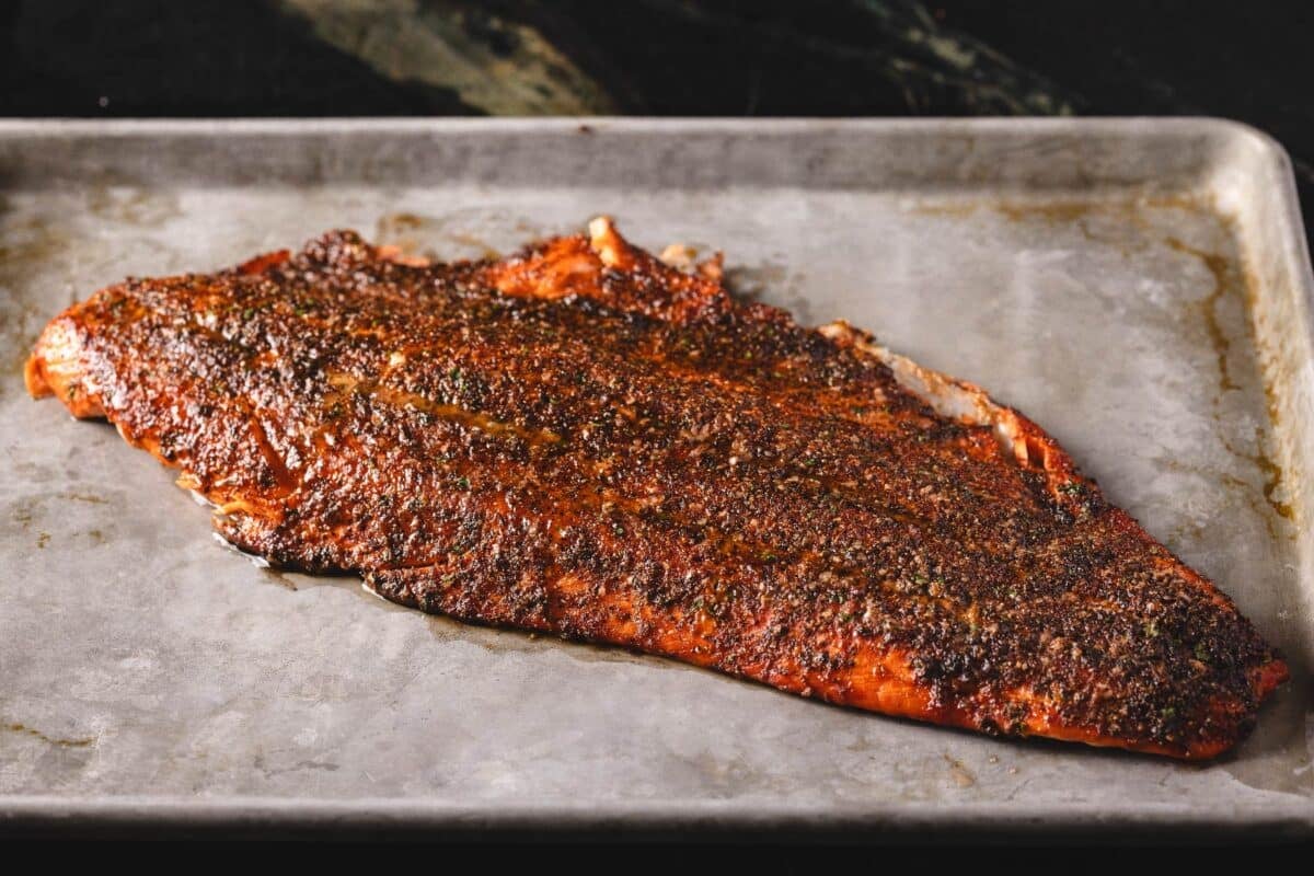 Grilled steelhead trout on a metal baking sheet.