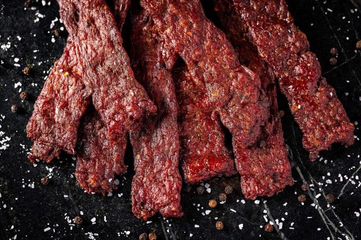 Ground venison jerky piled on a black platter.