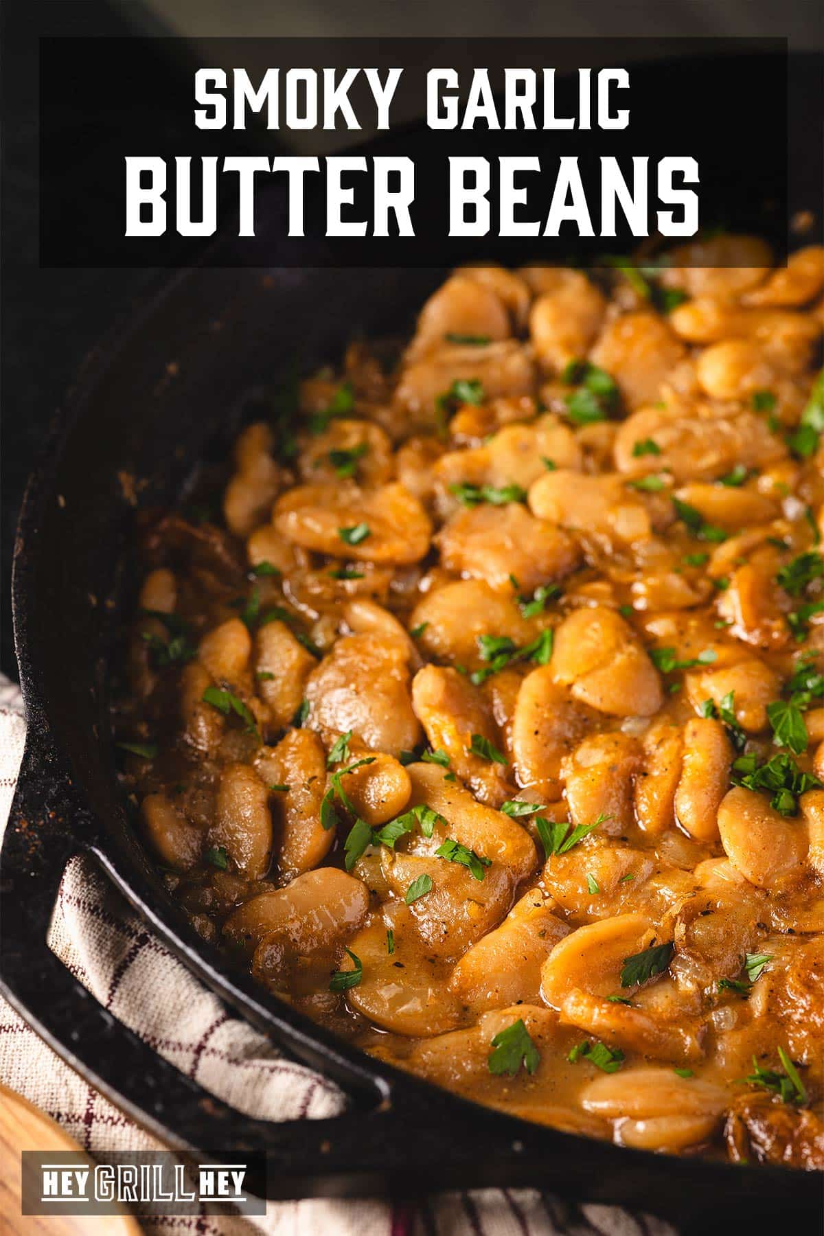 Cooked butter beans in a skillet. The text overlay reads "Smoky Garlic Butter Beans" at the top and "Hey Grill Hey" at the bottom.