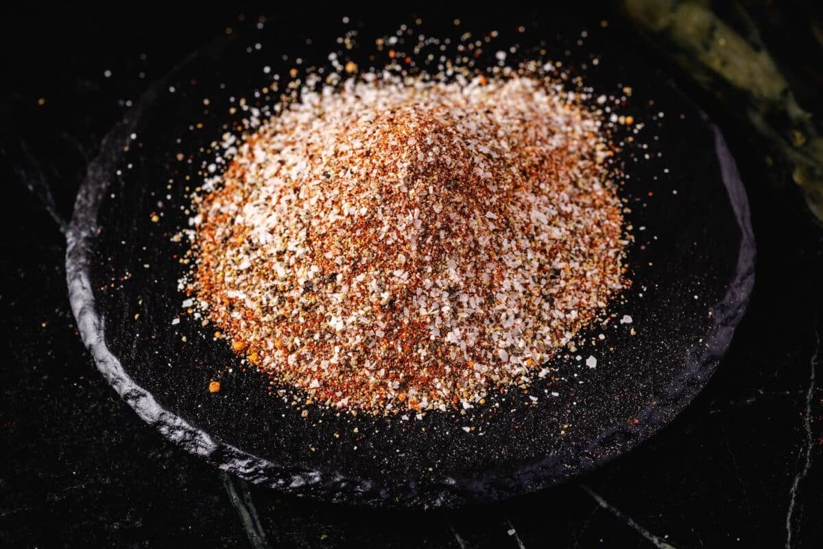 A pile of spices on a black stone platter.