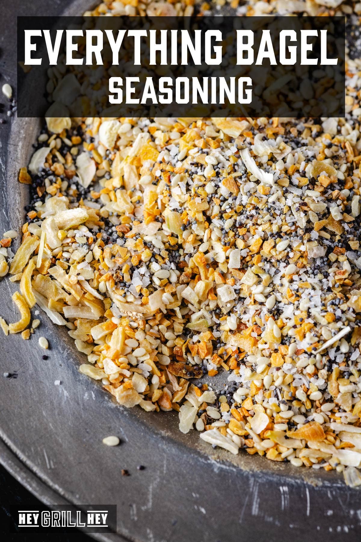 A metal plate topped with a seasoning blend. The text overlay reads "Everything Bagel Seasoning" at the top, and "Hey Grill Hey" at the bottom.