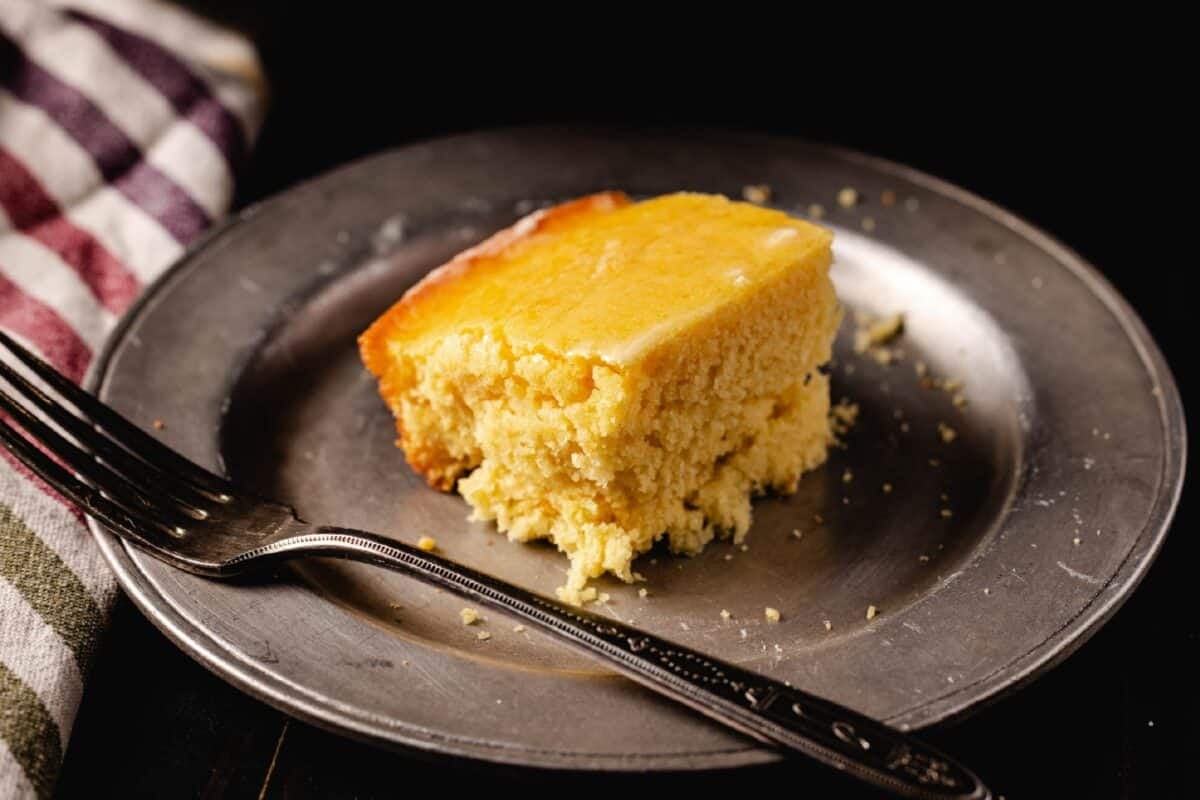 A metal plate with a cornbread square and a fork.