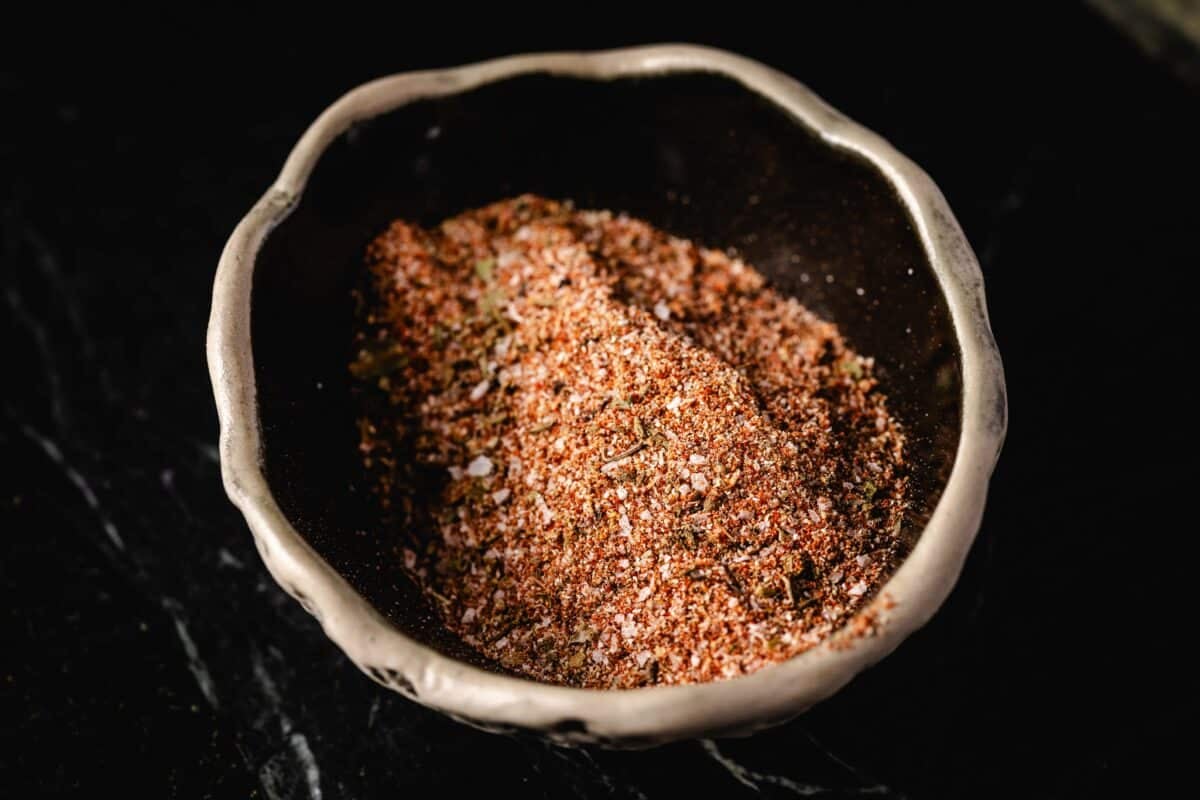 A dry rub on a decorative bowl on a black surface.