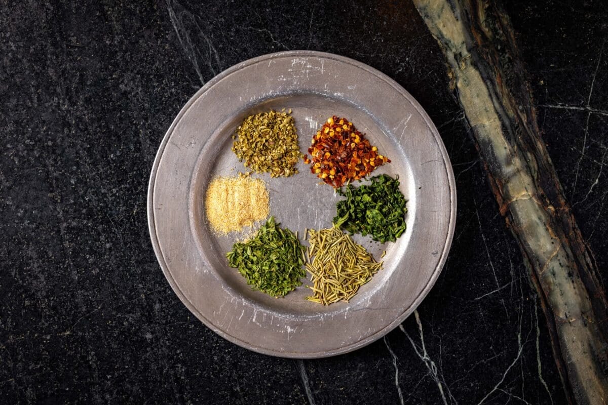 A metal plate with 6 small piles of spices.