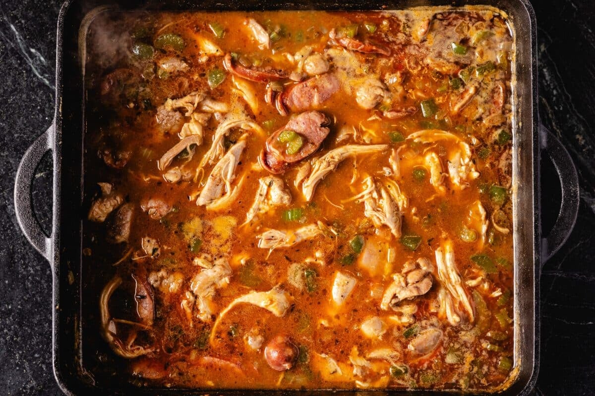 A cast iron pot filled with a chicken stew.