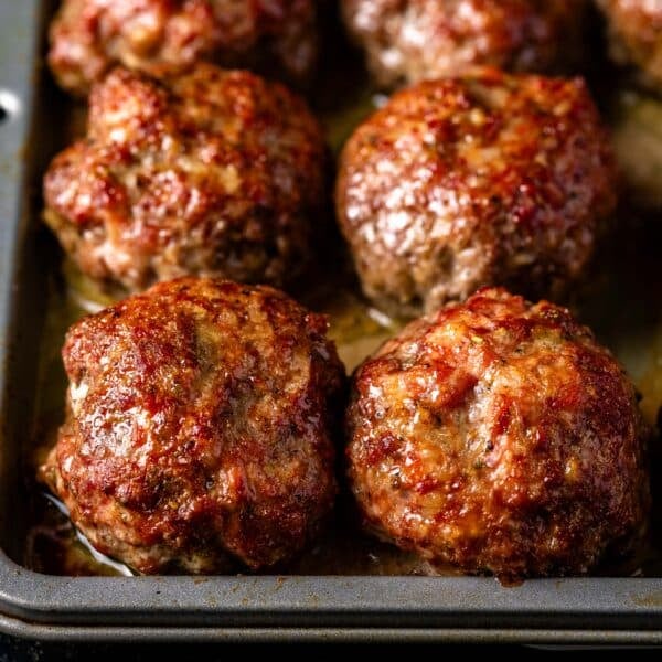 A baking sheet lined with Italian meatballs.