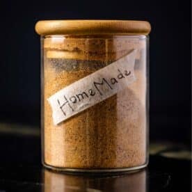 A glass jar filled with seasoning with a handmade label that says "homemade" on it.