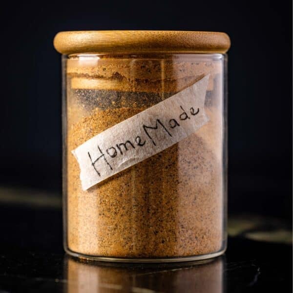 A glass jar filled with seasoning with a handmade label that says "homemade" on it.