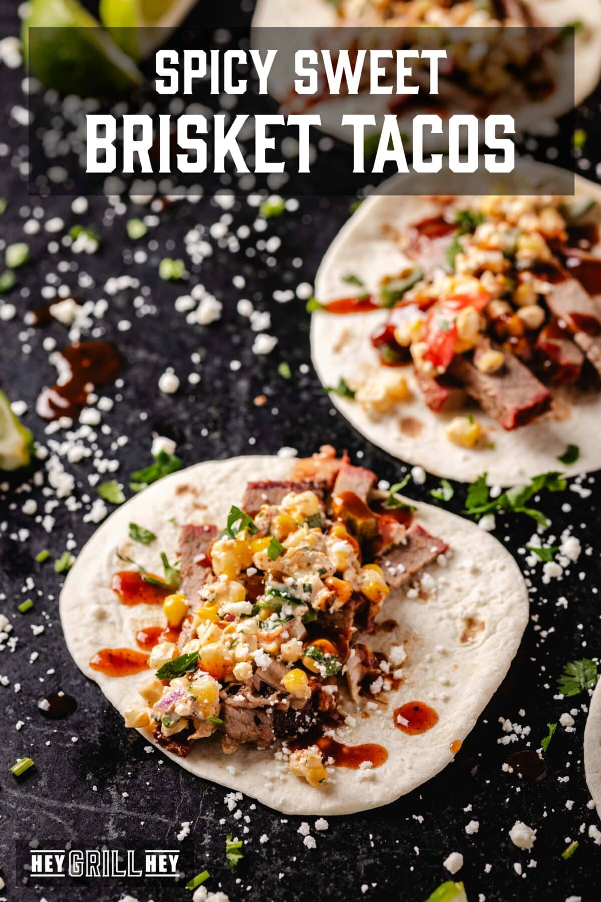 Open soft tacos on a black surface sprinkled with Cotija cheese. The text overlay reads "Spicy Sweet Brisket Tacos" at the top, and "Hey Grill Hey" at the bottom.