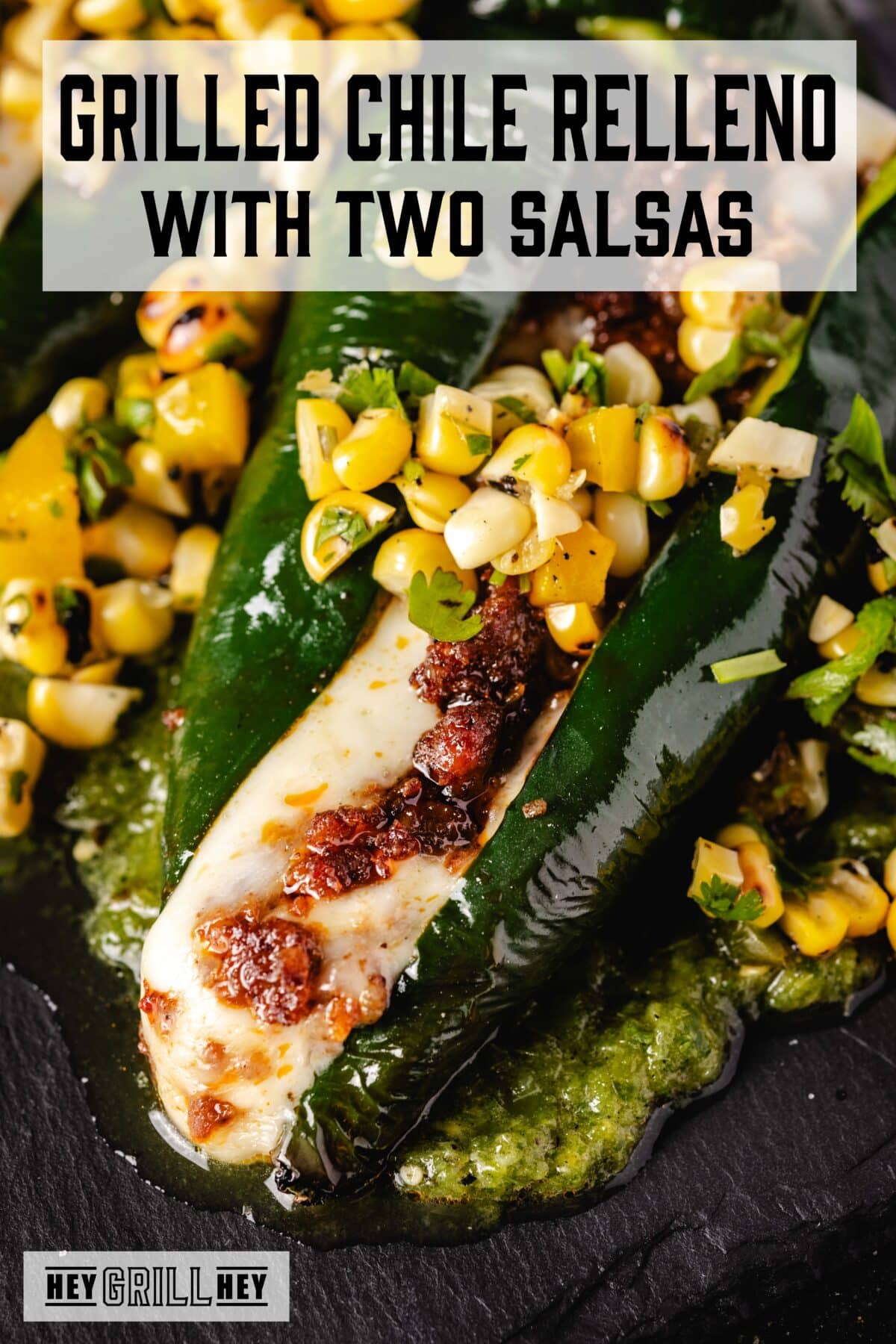 A grilled, stuffed chile topped with corn salsa. The text overlay reads "Grilled Chile Relleno with Two Salsas" at the top, and "Hey Grill Hey" at the bottom.