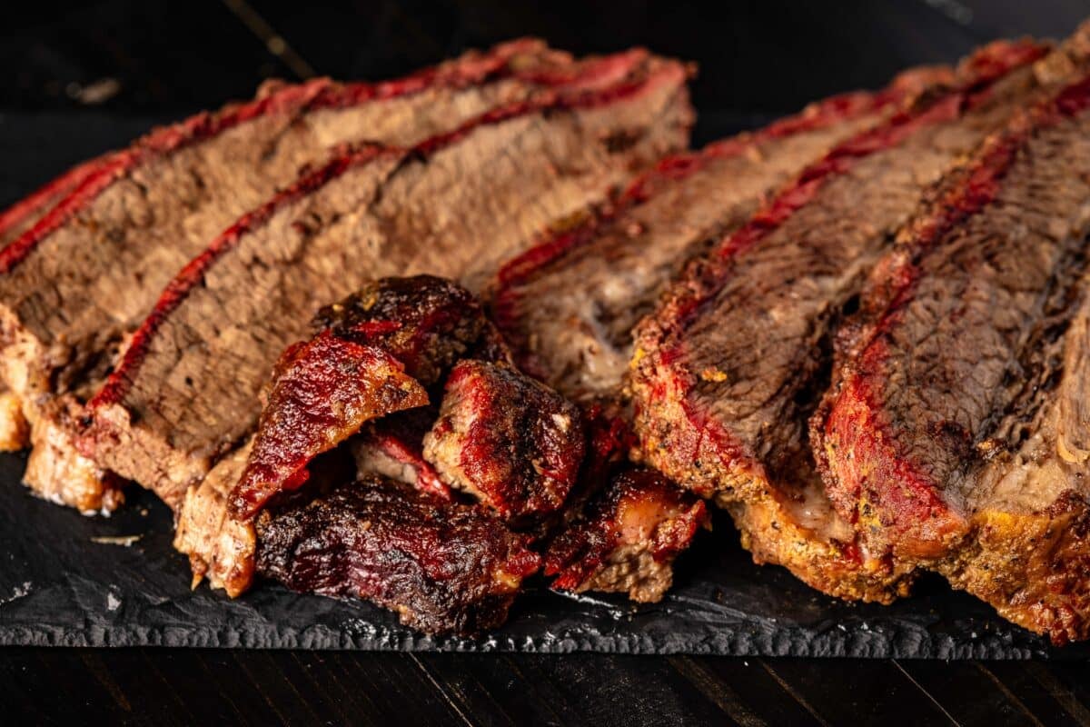 Sliced Hot and Fast Brisket on a black platter.