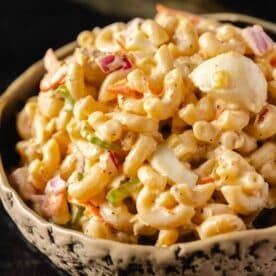 A bowl of tuna macaroni salad with chopped eggs and veggies.