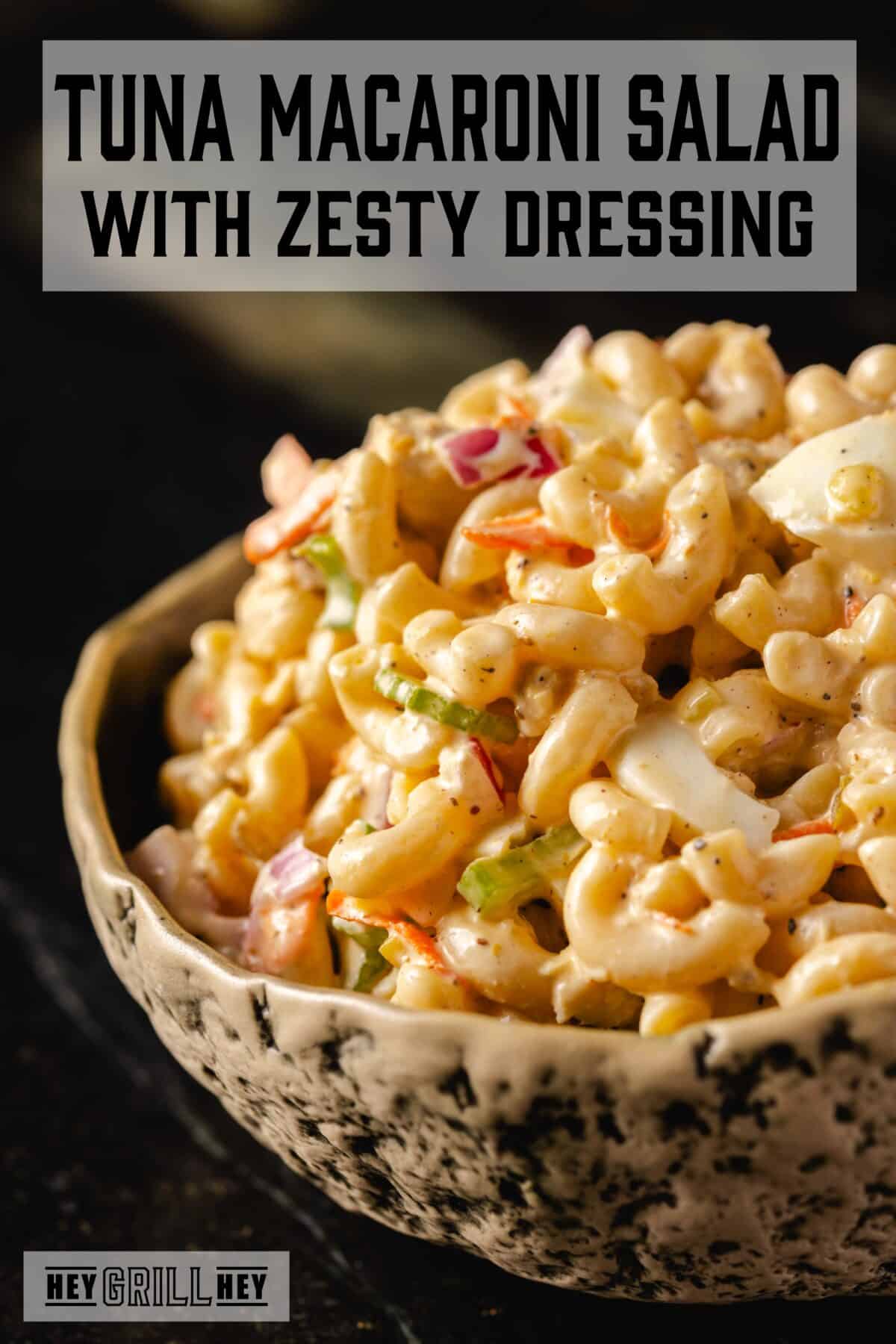 A bowl of tuna macaroni salad with chopped eggs and veggies. The text overlay reads "Tuna Macaroni Salad" at the top, and "Hey Grill Hey" at the bottom.