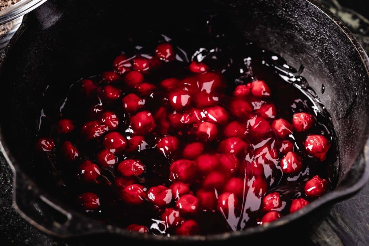A cast-iron pot with cherry pie filling inside.
