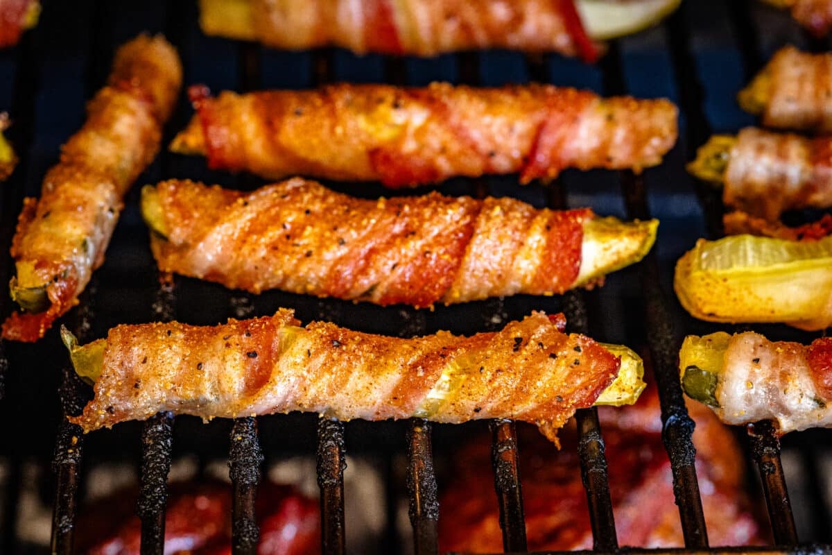 Pickle wedges in a bacon wrap on the smoker.