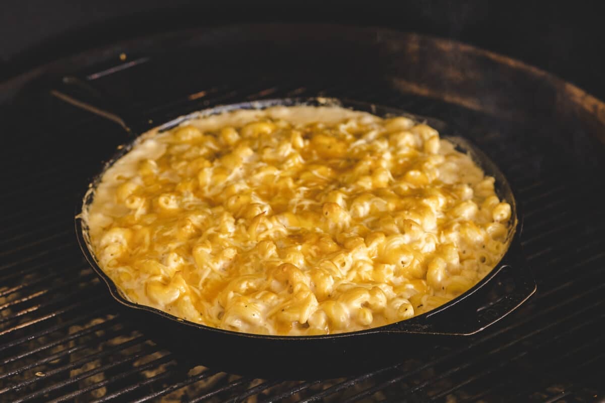 A mac and cheese recipe being cooked in a skillet on the grill.