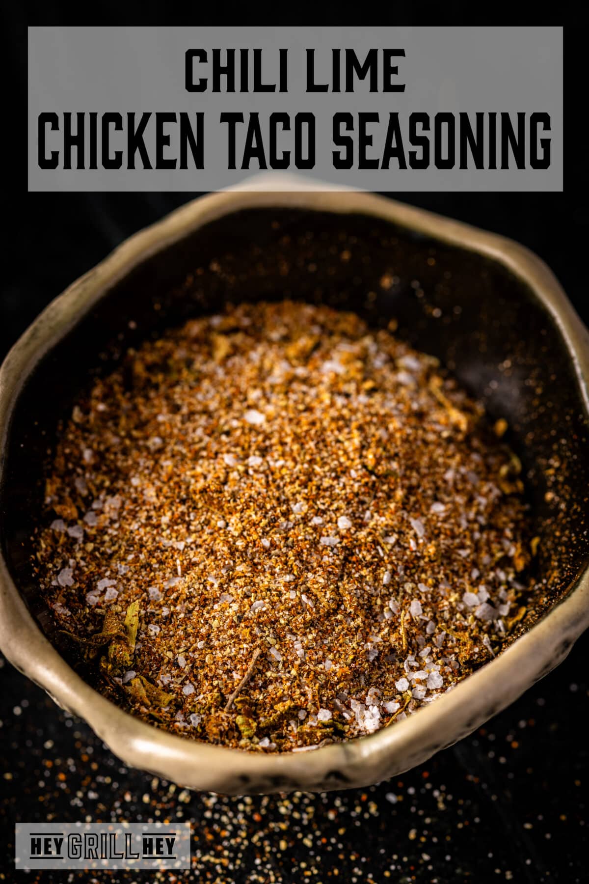 A bowl full of seasoning on a black background. The text overlay reads "Chili Lime Chicken Taco Seasoning" at the top, and "Hey Grill Hey" at the bottom.