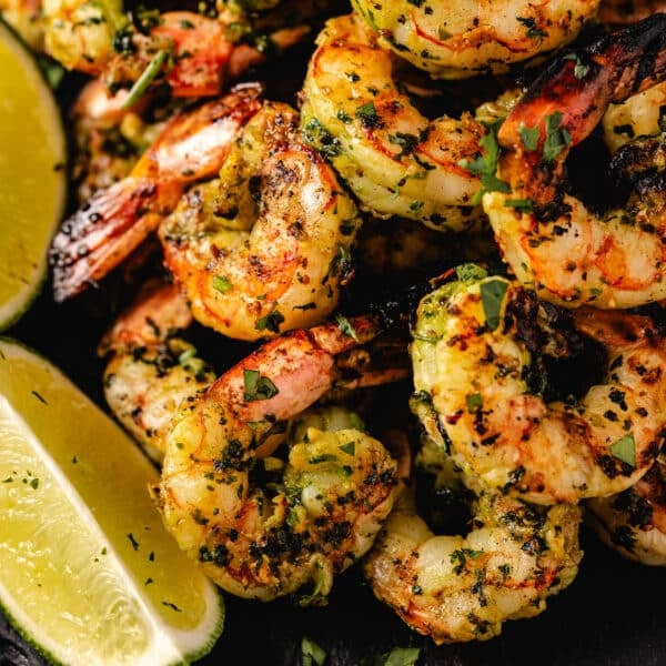 Grilled shrimp next to lime wedges.