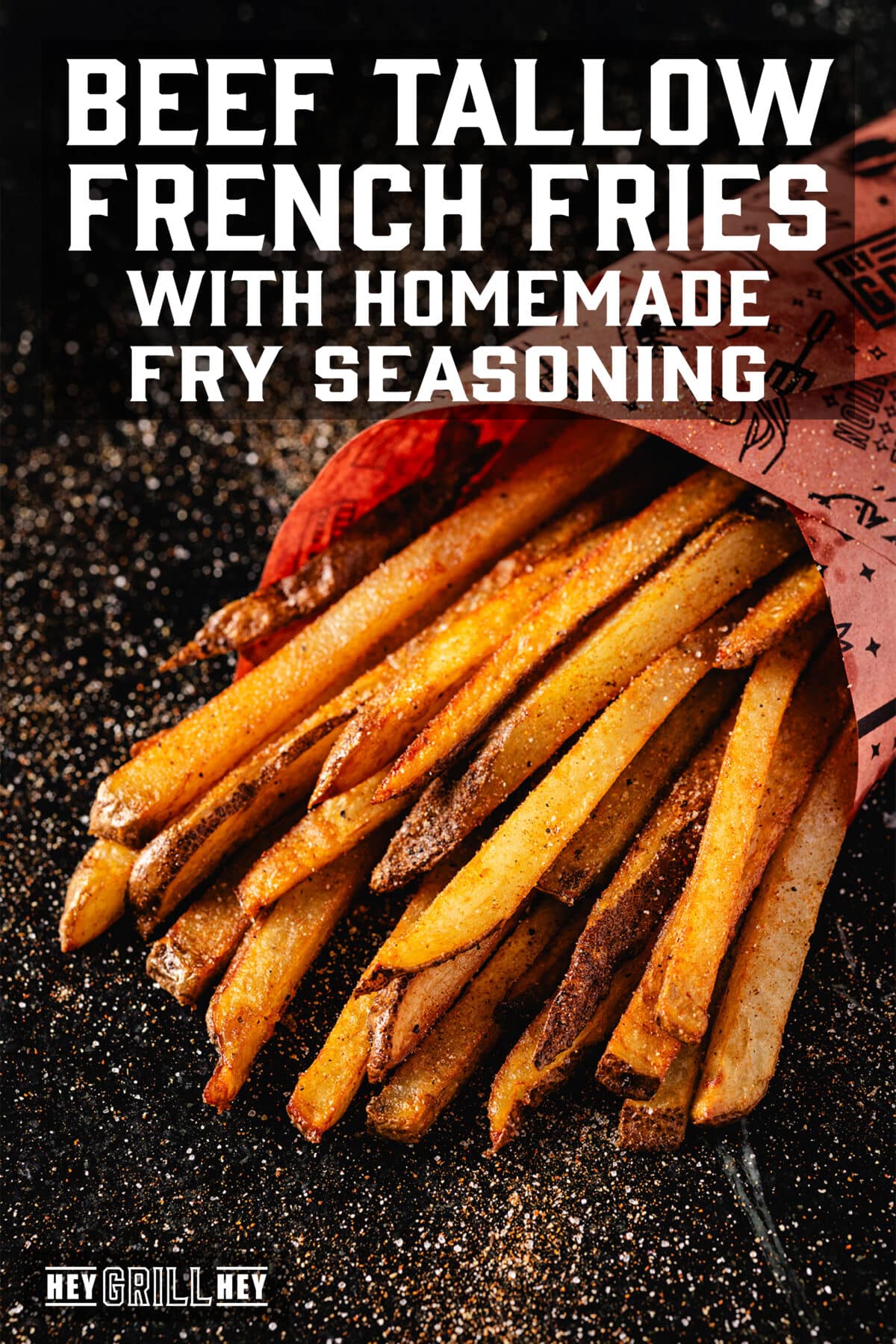 A batch of French fries wrapped in peach butcher paper. The text overlay reads "Beef Tallow French Fries. with a Homemade Fry Seasoning" at the top, and "Hey Grill Hey" at the bottom.