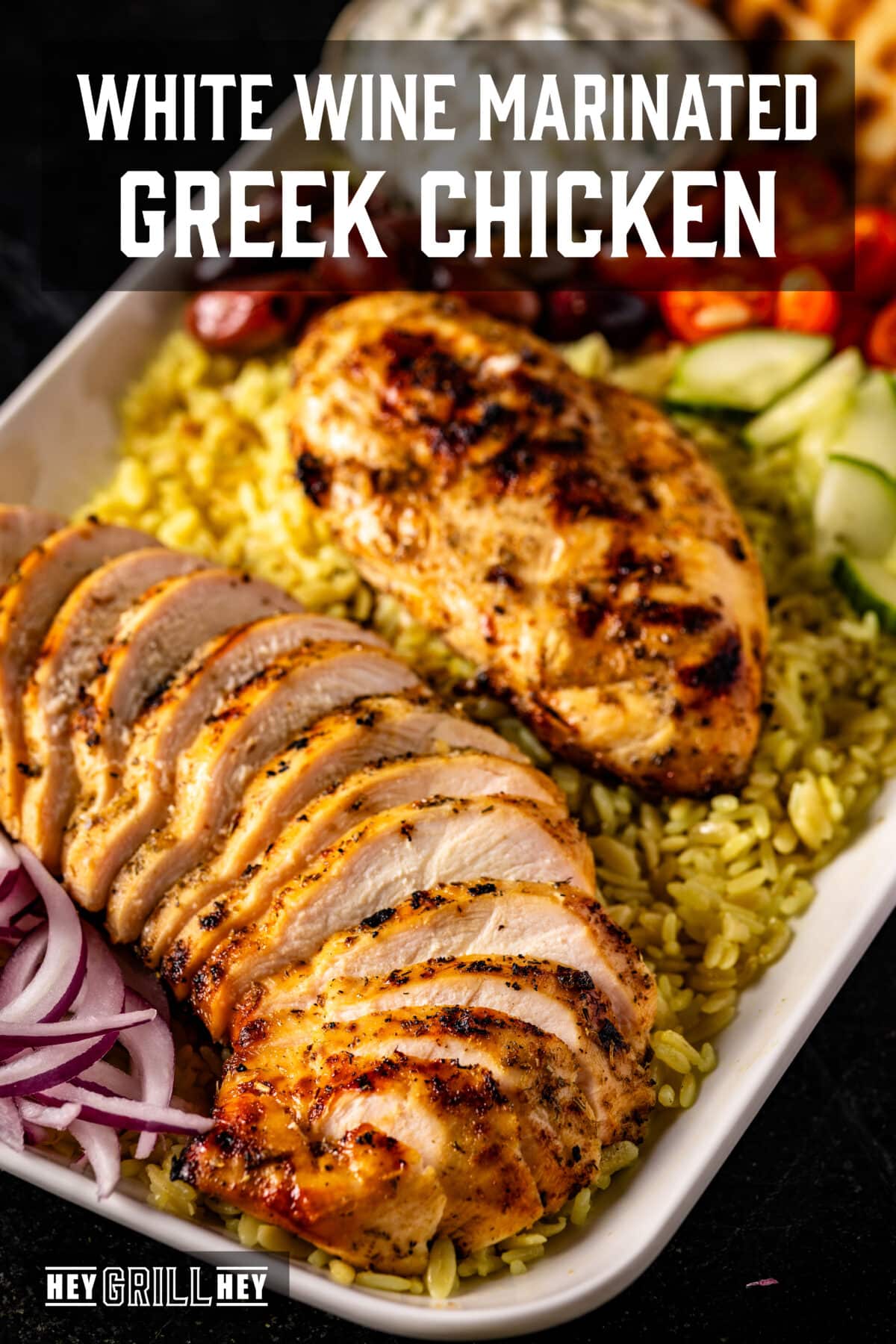A white platter of sliced chicken and veggies on a bed of rice. The text overlay reads "White Wine Marinated Greek Chicken" at the top, and "Hey Grill Hey" at the bottom.