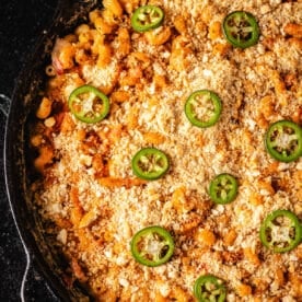 A closeup shot of a bacon jalapeño mac and cheese in a cast iron skillet.