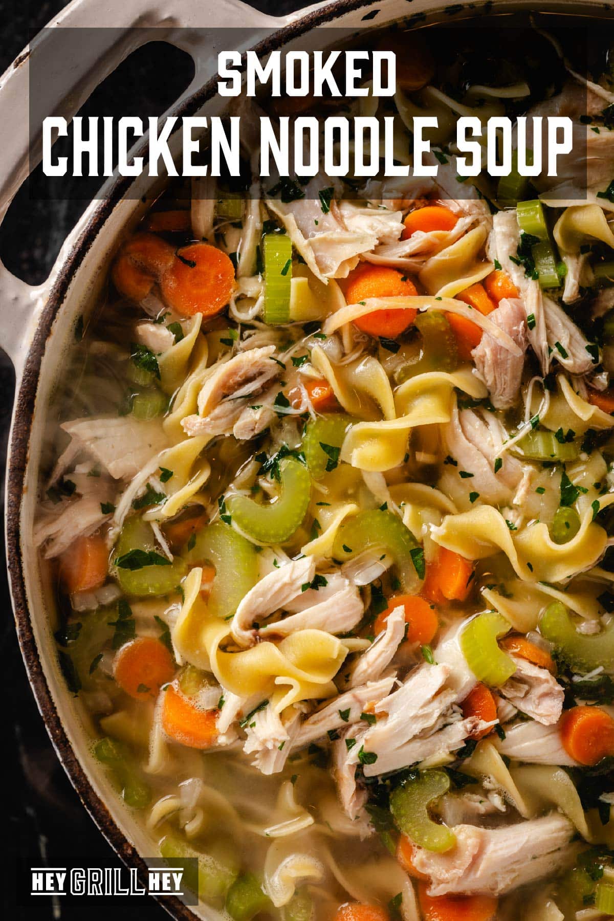 A large, white pot filled with chicken noodle soup. The Text overlay reads "Smoked Chicken Noodle Soup" at the top, and "Hey Grill Hey" at the bottom.