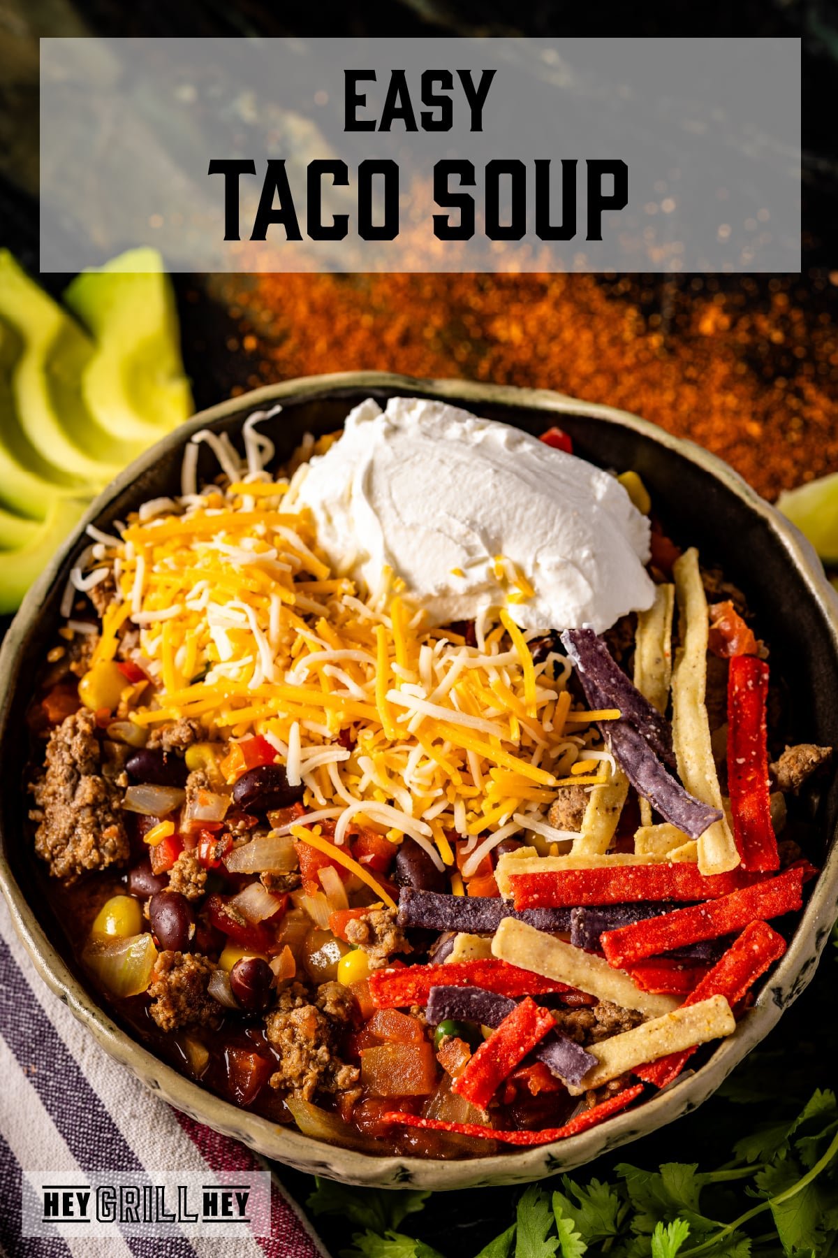A bowl of taco soup topped with shredded cheese, tortilla strips, and a dollop of sour cream. The text overlay reads "Easy Taco Soup" at the top, and "Hey Grill Hey" at the bottom.